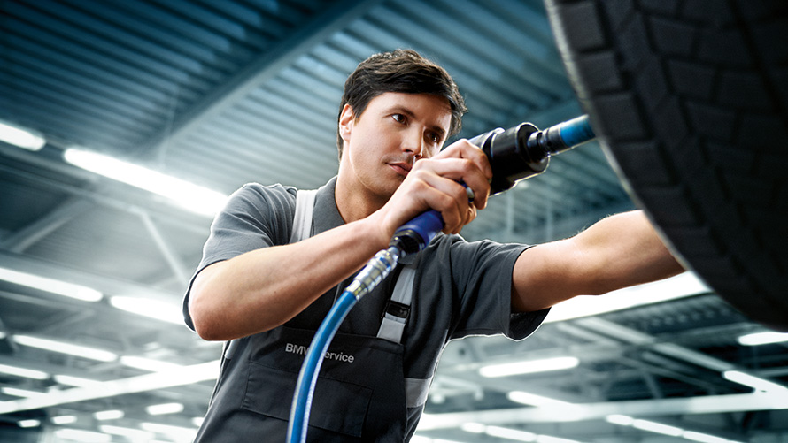Offerte Service Pneumatici BMW Offerte BMW per l'estate un addetto del Service Pneumatici BMW ripara una BMW