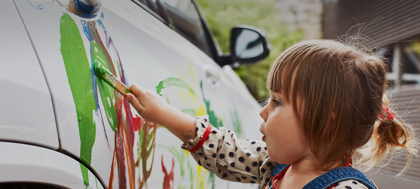 Una bambina dipinge su una BMW Una bambina dipinge su una BMW