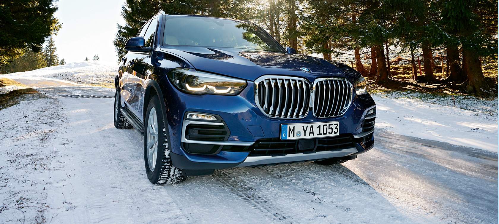 Accessori Invernali BMW BMW X3 blu su strada innevata, vista anteriore a tre quarti