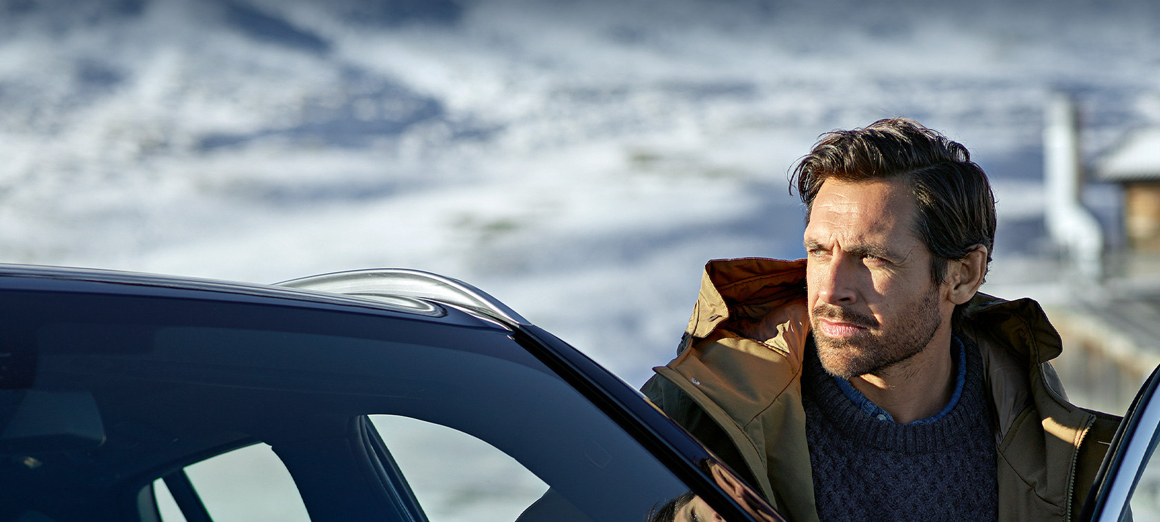 Accessori Originali BMW e Servizi BMW per l'autunno e l'inverno Uomo con parka invernale davanti alla portiera della sua BMW