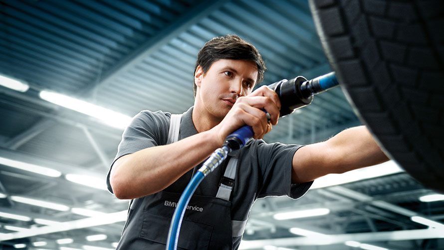 Service ruote BMW Assistenza Pneumatici BMW. Un meccanico dell’assistenza clienti BMW ripara una BMW