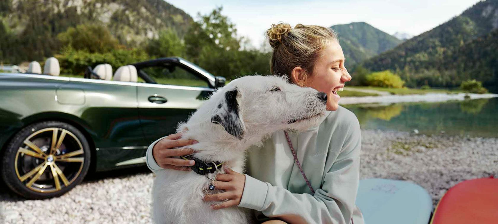 BMW in riva ad un lago con ragazza e cane BMW in riva ad un lago con ragazza e cane