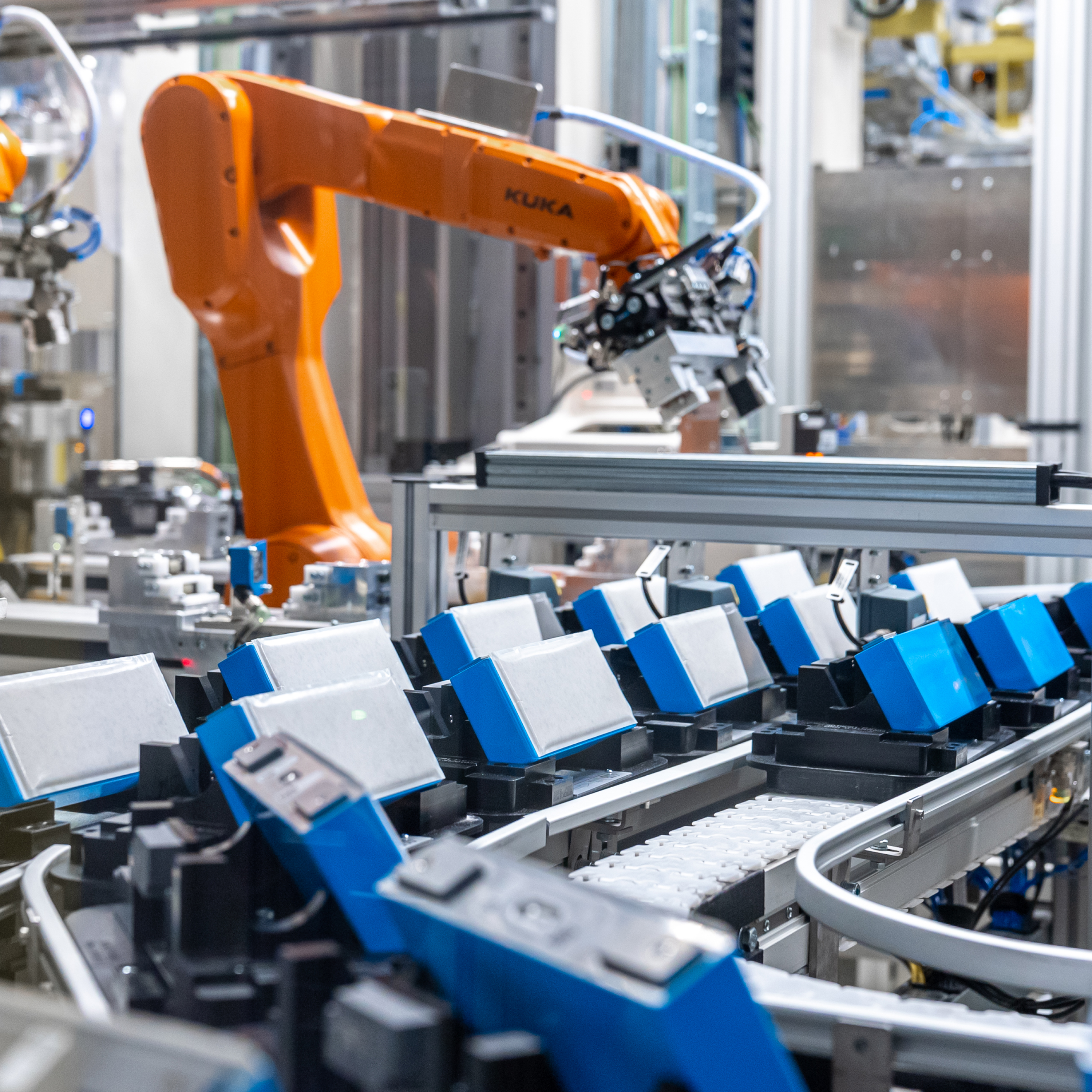Un primo piano di diverse batterie blu e bianche su nastro nello stabilimento BMW