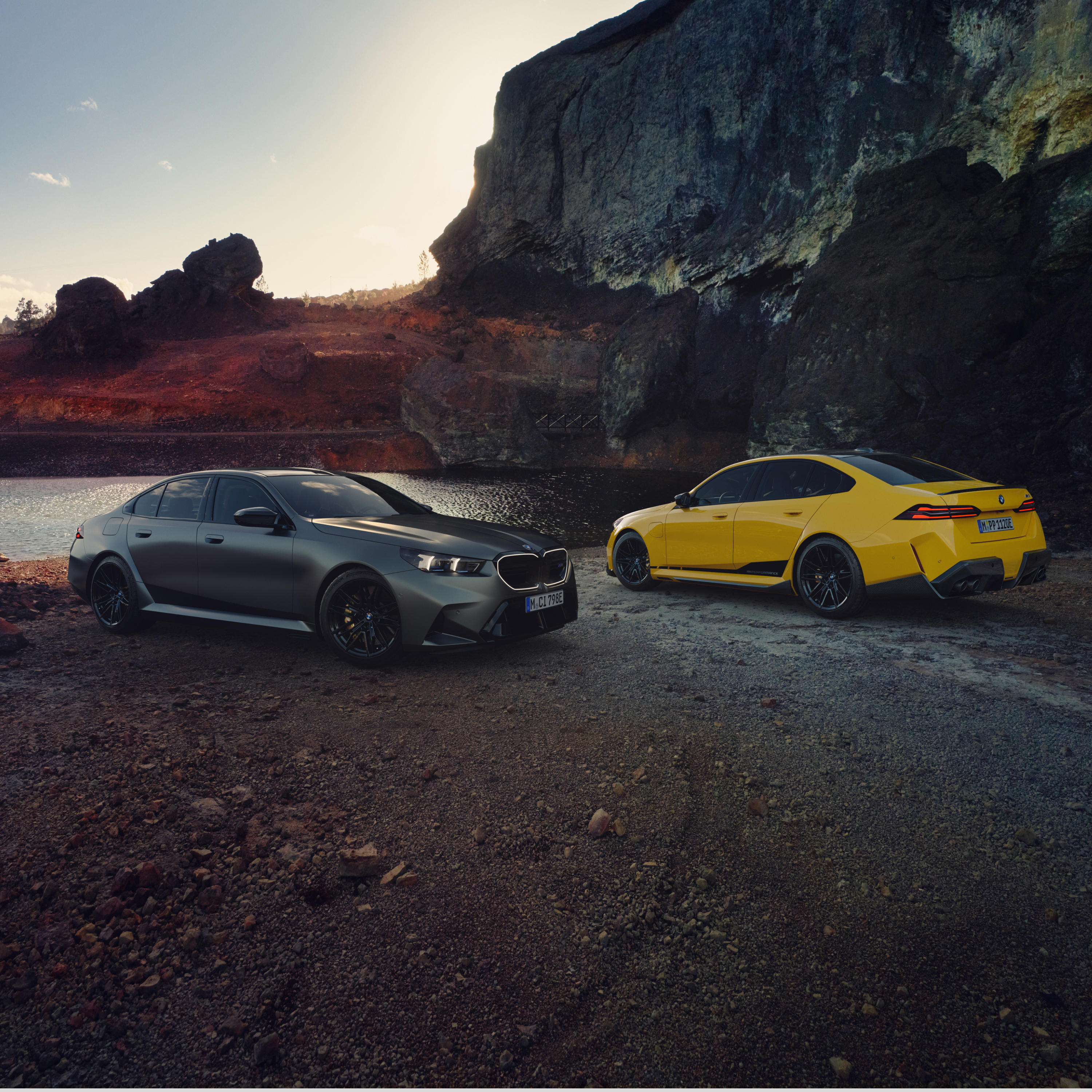 Due BMW Serie 5 ferme sulla spiaggia di fronte a una parete rocciosa
